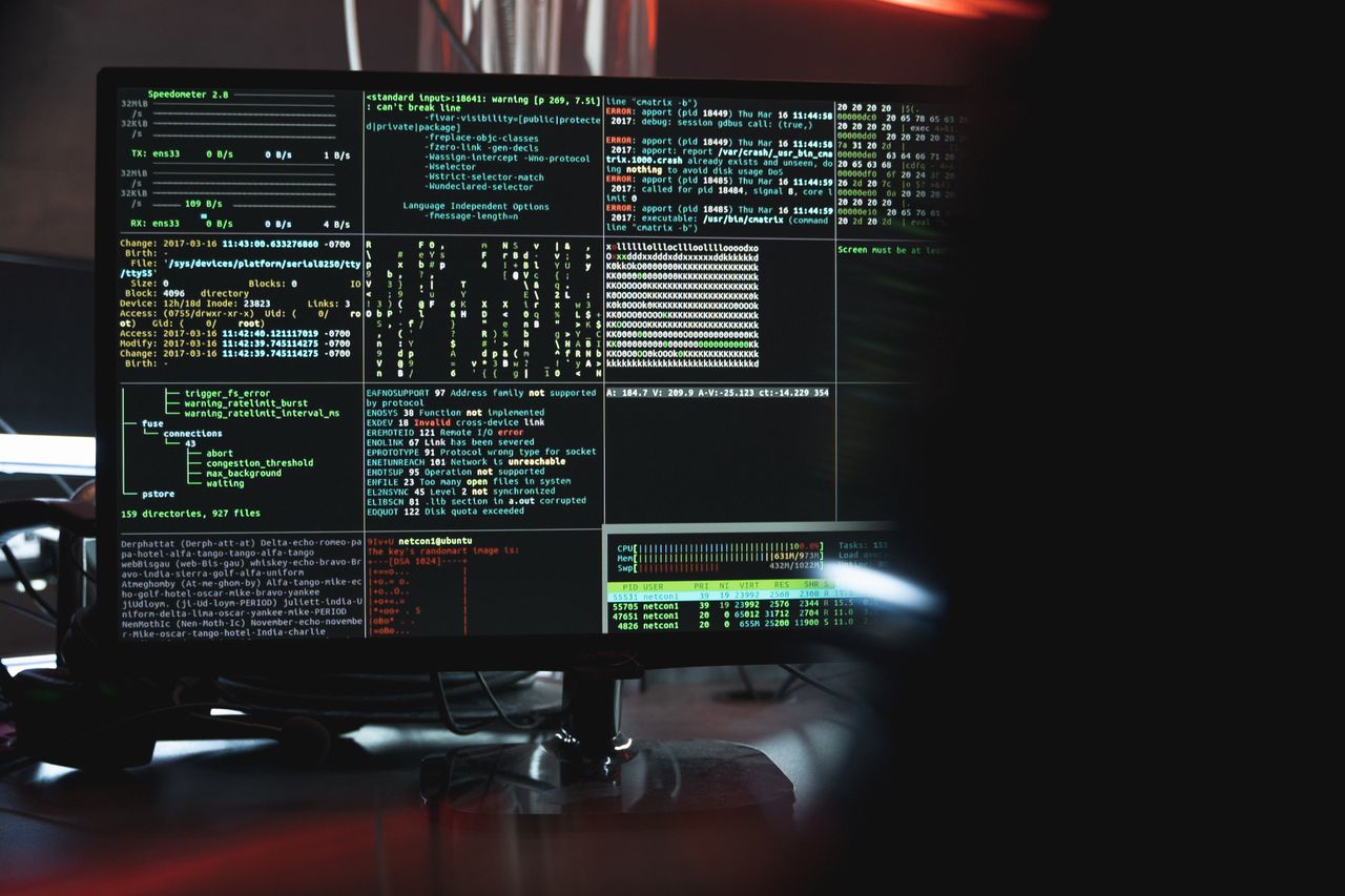 Services Close-up of a computer monitor displaying cyber security data and code, indicative of system hacking or programming.