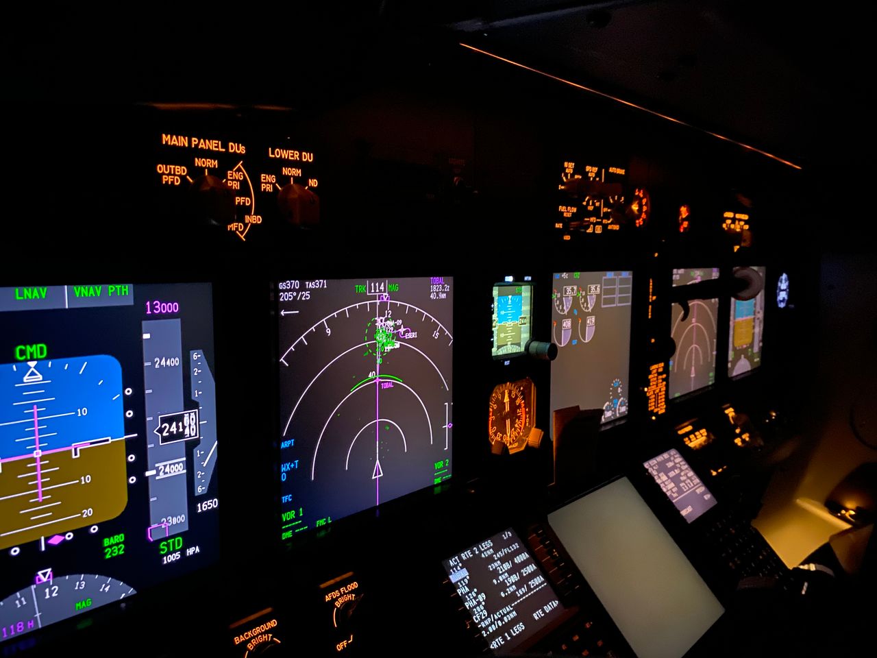 Services A focused view of an aircraft cockpit control panel with various illuminated screens.